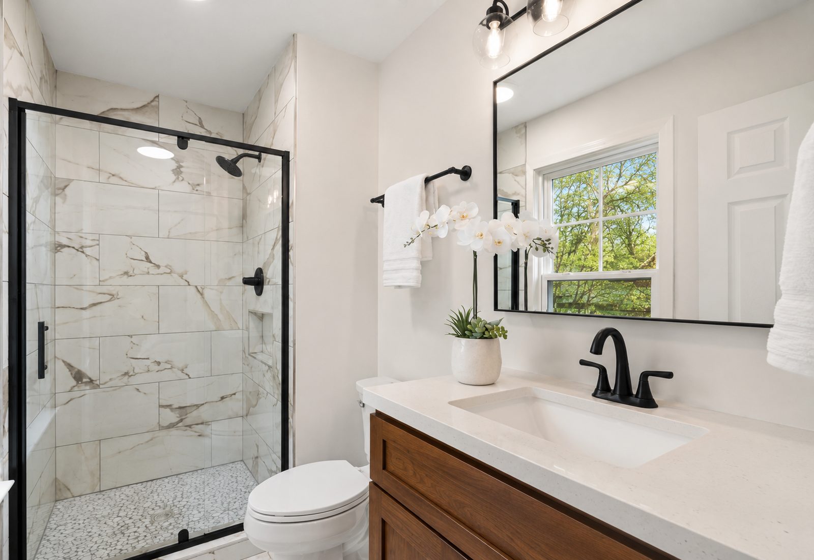 Updated bathroom with a new vanity, faucet and framed mirror