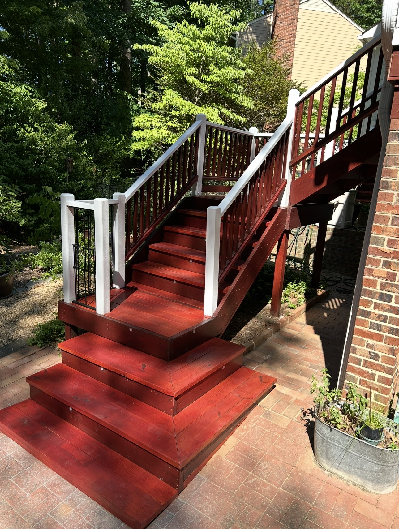 Refinished exterior deck stairs and landing with railing details.